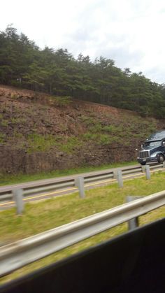 a truck is driving down the highway with another car behind it