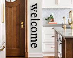 there is a door with the words welcome on it and a kitchen in the background