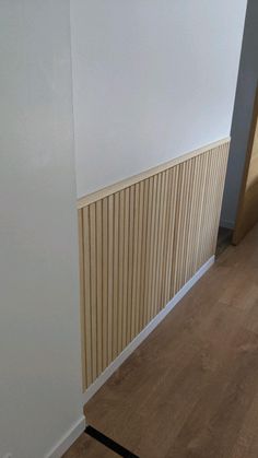 an empty room with wood flooring and white walls, along with a radiator