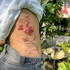 a woman's stomach with pink flowers on her side and the bottom part of her body