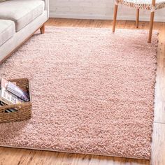 a living room with a couch, coffee table and rug on the floor in front of it