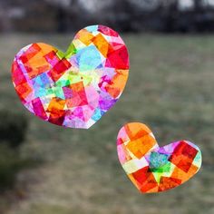 two paper hearts are hanging in the air