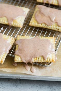 several pastries on a cooling rack with sauce drizzled over them