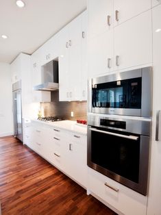 an empty kitchen with white cabinets and stainless steel appliance on the counter top