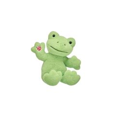 a green frog stuffed animal sitting on top of a white surface with one leg up