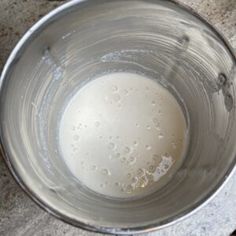 a metal bowl filled with liquid on top of a table