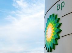 a bp sign is shown on the side of a large white building with green and yellow logos