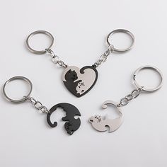 three different key chains with cats and hearts shaped like heart shapes on them, one has a cat's head in the shape of a heart