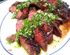 steak with parsley on top served on a white and blue plate, ready to be eaten