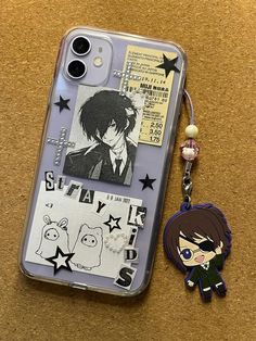 a cell phone case with an anime character keychain attached to the back of it