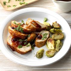 a white plate topped with meat and brussel sprouts