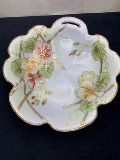 a white and gold plate with flowers on it