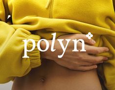 a close up of a person wearing a yellow sweater with the word polyn on it