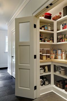 an open pantry door in a kitchen with lots of food on the shelves and other items