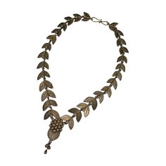 This sterling necklace of laurel leaves and berries is based on a suite of jewelry produced by Italian jeweler Carlo Guiliano circa 1863 in the classical taste. The original suite is in high carat gold as a parure with tiara, necklace, bracelet and earrings. Perfect for Aesthetic devotees of 19th Century society. This 20th Century reproduction is beautifully made in gilt silver with English makers marks. Beautiful quality. UK 1970's. 20 inch". Widest link 1 ", Drop 2.75. Excellent condition. Elegant Antique Gold Temple Necklace For Ceremonial Occasions, Elegant Temple Necklace With Antique Finish As Gift, Elegant Brass Temple Necklace With Oxidized Finish, Ornate Formal Necklace With Oxidized Finish, Elegant Antique Finish Pendant Necklaces, Elegant Silver Necklace With Antique Finish, Elegant Antique Gold Ceremonial Necklace, Elegant Engraved Temple Necklace For Festive Occasions, Elegant Engraved Temple Necklace For Ceremonial Use