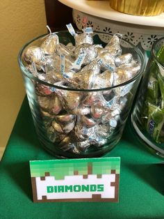 a bowl full of candy sitting on top of a table next to a sign that says diamonds