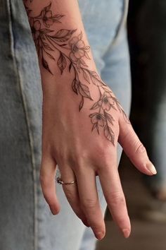 a woman's hand with a flower tattoo on it