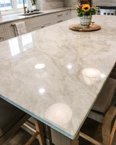 a kitchen island with white marble counter tops