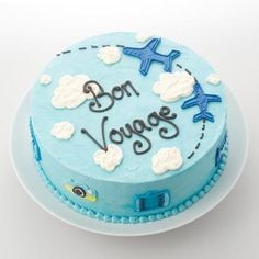 a blue cake with an airplane and the words bon voyage written on it is sitting on a white plate