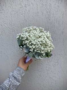 a person holding a bouquet of white flowers