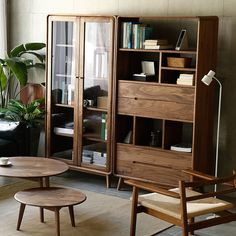 a living room filled with furniture and a book shelf in front of a large window