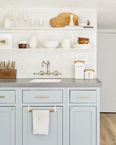 a kitchen with blue cabinets and white walls