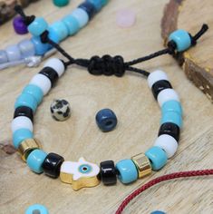 a wooden table topped with bracelets and beads