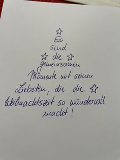 a piece of paper with writing on it that is written in blue ink and has a christmas tree