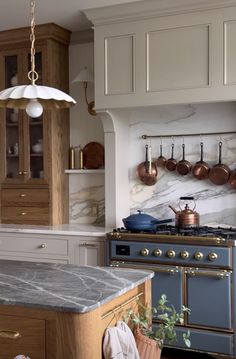 a kitchen with marble counter tops and an island in front of a stove top oven