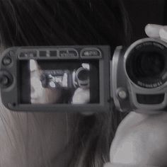 a woman holding up a camera to take a photo with it's reflection in the mirror