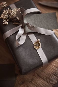 a present wrapped in black and grey paper with a ribbon