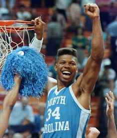 a basketball player dunks the ball in front of his team mates during a game