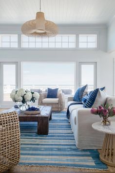 the living room is decorated in blue and white colors, with wicker furniture on either side