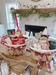 two baskets filled with gifts sitting on top of a table in front of a fireplace