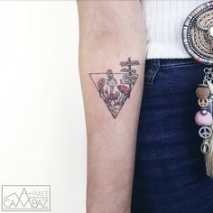 a woman's arm with a tattoo on it and a cross in the middle