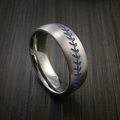 a baseball ring with blue stitching on it sitting on top of a wooden table