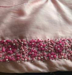 pink and white embroidered fabric with flowers on it