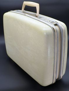 three pieces of white luggage sitting on top of a table