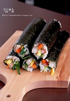 two sushi rolls on a wooden cutting board