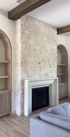 a living room with a couch, fireplace and bookcases in front of it