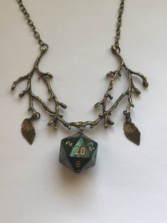 a necklace with some charms hanging from it's sides on a white table top