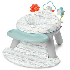 a baby's high chair that is sitting on the ground with toys in it