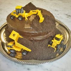 there is a cake made to look like a construction site with dump trucks on it