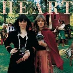 two women standing next to each other on the cover of heart magazine, with people dressed in costume