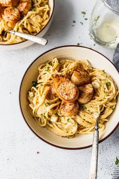 two bowls filled with pasta and scallops