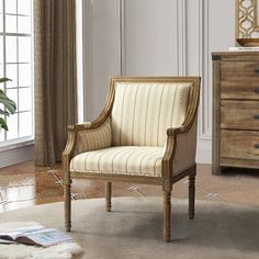 a chair sitting on top of a rug in front of a dresser and window sill