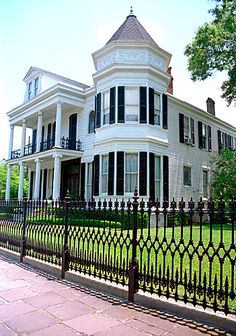 a large white house sitting on the side of a road