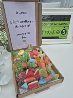 a box filled with gummy bears sitting on top of a table next to a sign