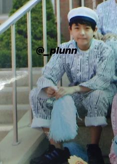 two young boys sitting on the steps next to each other and one is wearing a sailor's hat