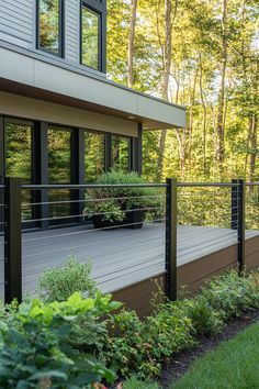 a deck in front of a house with plants growing on it's railings